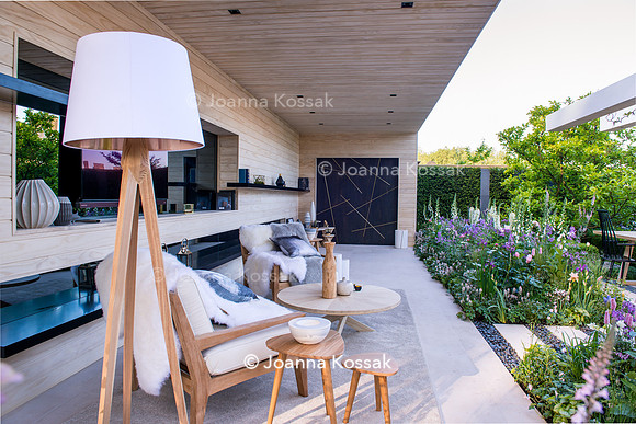 Modern patio with TV, lamp, wooden chairs, tables, made from Accoya (design by Nils Verweij), the path and flowerbeds with Persicaria bistorta 'Superba', Hesperis matronalis, Rosa 'Natasha Richardson'