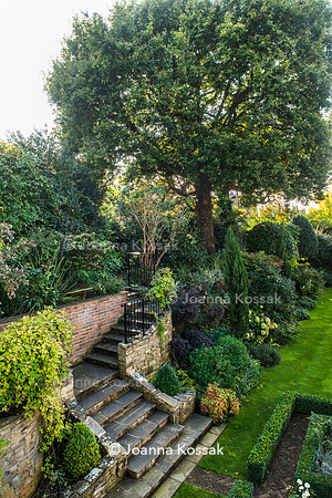 Stone stairs amongst flowerbeds in Autumn leading to upper level of the garden.